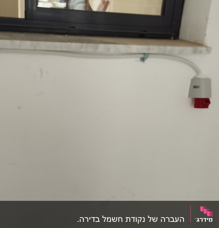שקע חשמל עם כבל גמיש על קיר לבן